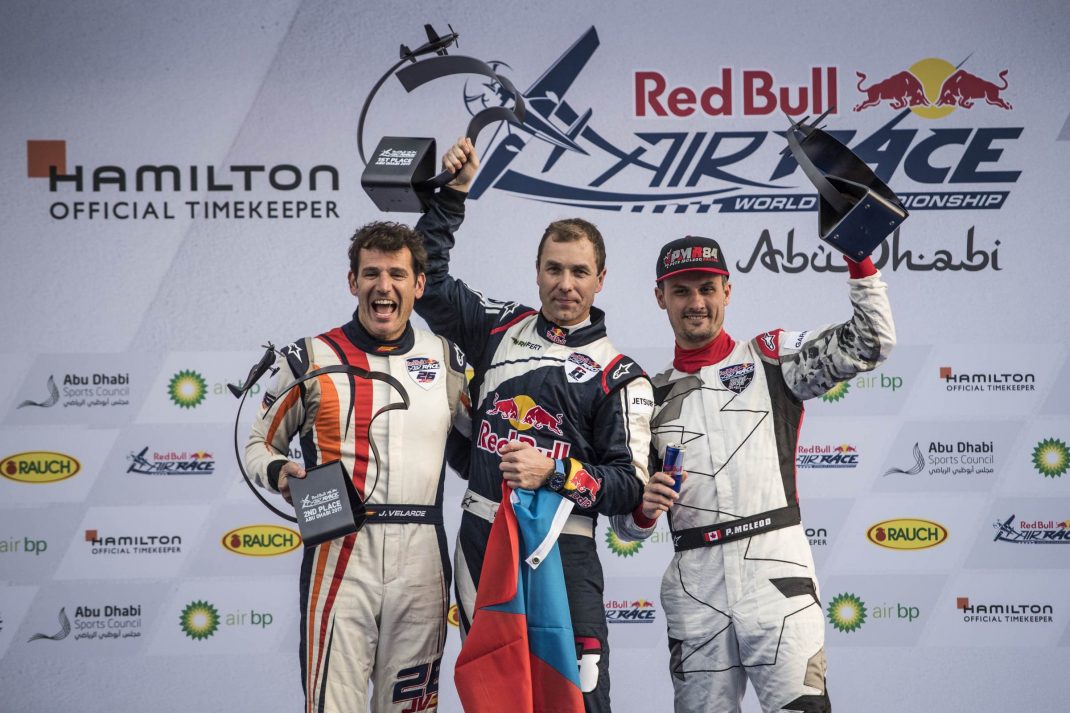 Martin Sonka of the Czech Republic (C), Juan Velarde of Spain (L) and Pete McLeod of Canada (R) celebrate during the Award Ceremony at the first stage of the Red Bull Air Race World Championship in Abu Dhabi, United Arab Emirates on February 11, 2017. 