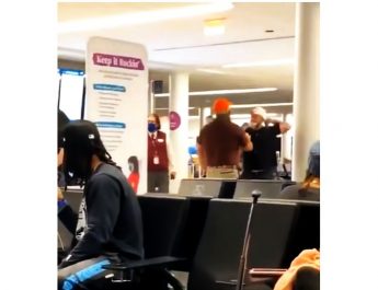 Trump-hívő (fekete pólóban, fehér sapkában) a Dulles repülőtéren, Washingtonban.